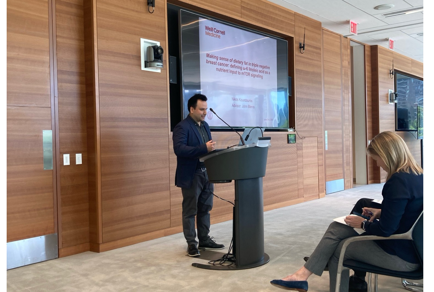 A man in a suit giving a presentation at a podium