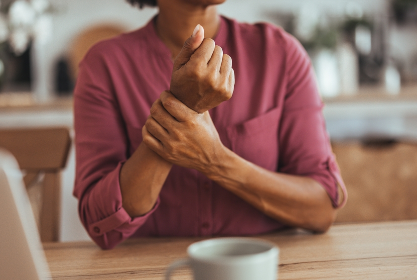photo of Black woman holding her wrist as though it hurts