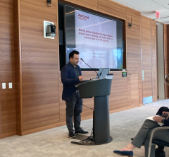 A man in a suit giving a presentation at a podium