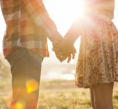 image of man and woman holding hands in the sunlight